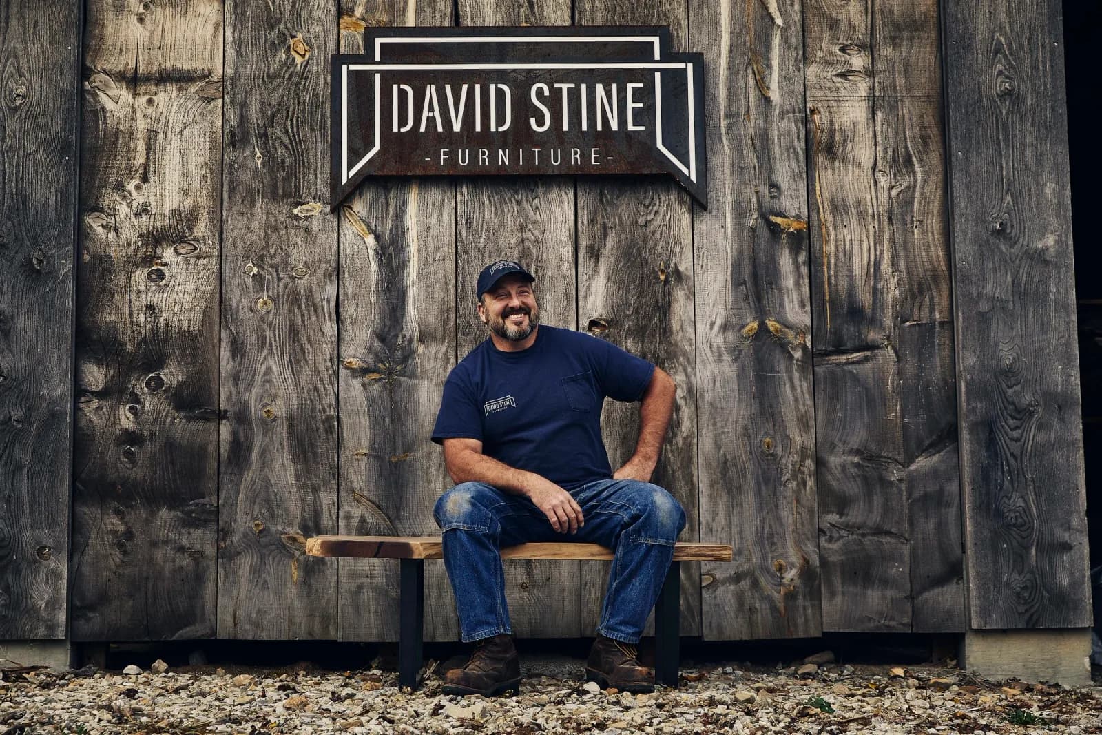 David Stine on a wooden bench outside his workshop