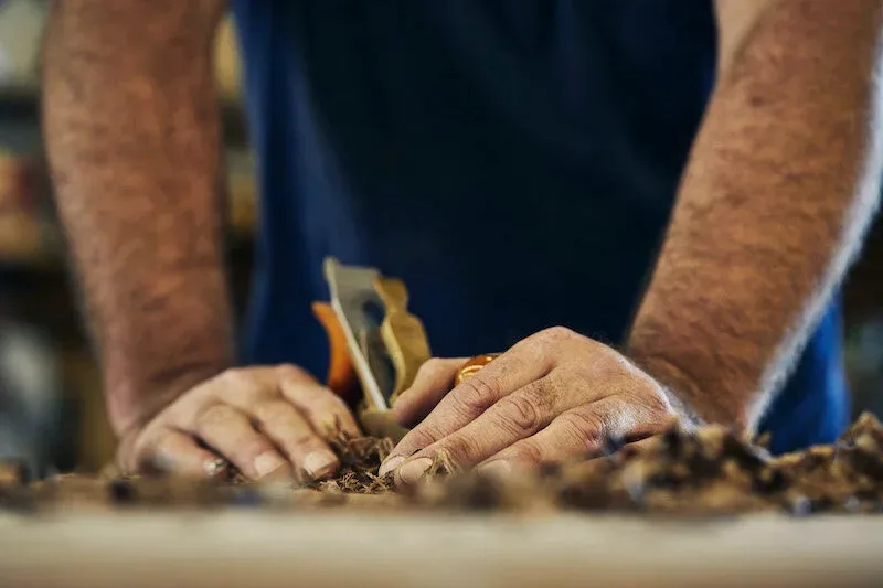 Hands shaping wood at the workbench