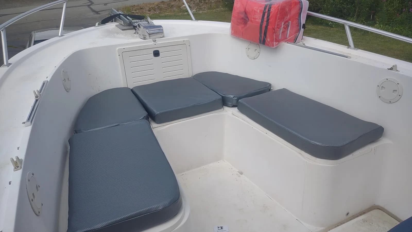 Grey seat cushions fitted around a boat cockpit, by Matsu Upholstery