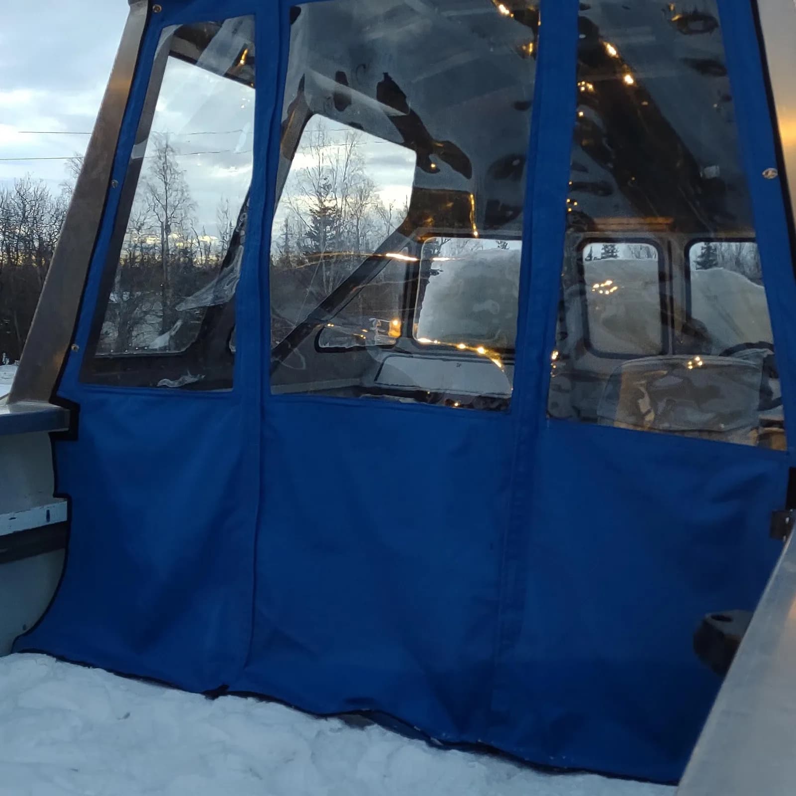 Blue canvas boat enclosure with clear windows, by Matsu Upholstery
